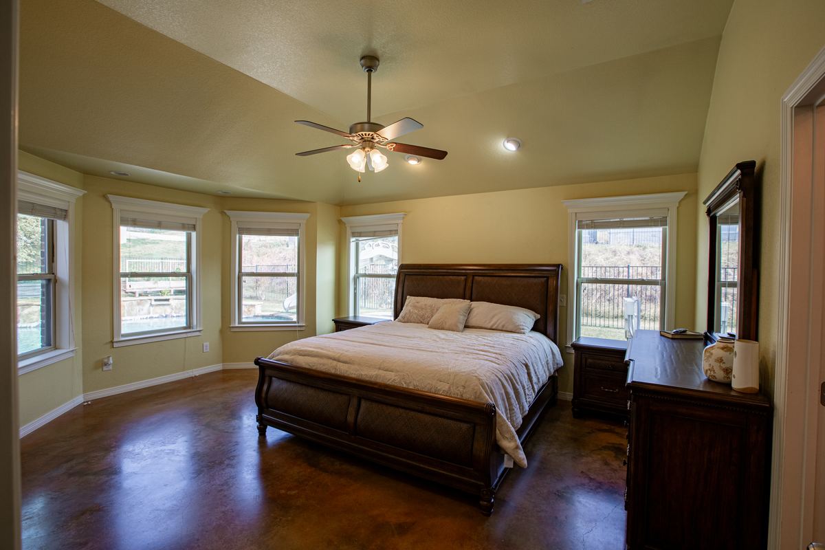 Master bedroom with king sleigh bed and bay windows looking out to the pool