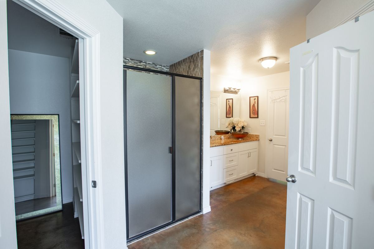 Walk-in shower with frosted glass door next to the vanity